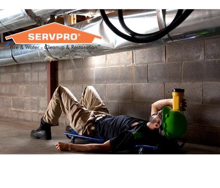 Man performing duct cleaning services with a SERVPRO logo